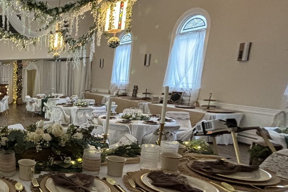 Fellowship hall set with round tables, arched windows and lanterns