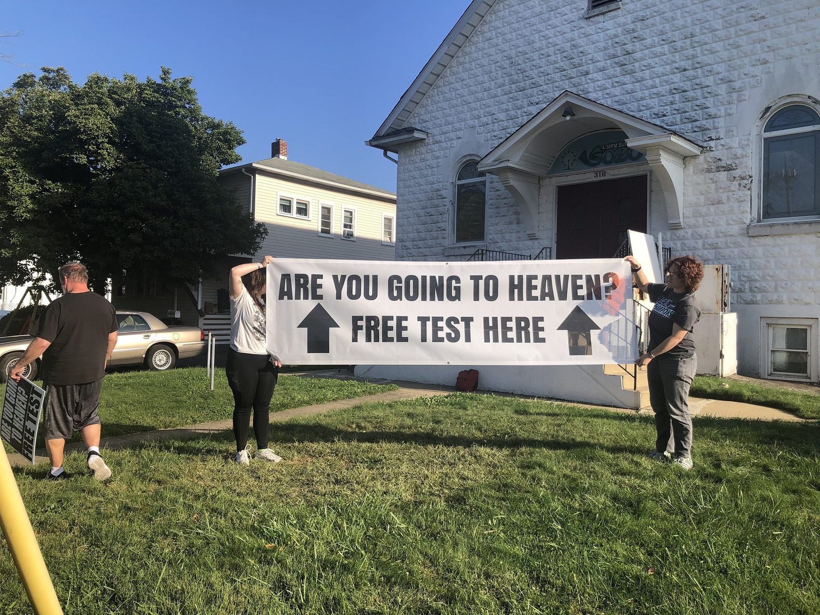 Volunteers with a banner on the front lawn of the campus